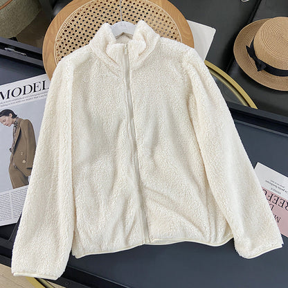 Giacca in pile bianco crema su tavolo, moda autunno inverno, chiusura zip, stile casual, tessuto morbido e caldo, ideale per look eleganti e confortevoli.