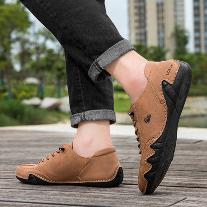 Scarpe da uomo in pelle marrone, suola nera antiscivolo, indossate all'aperto su passerella in legno. Design casual, ideale per passeggiate urbane.