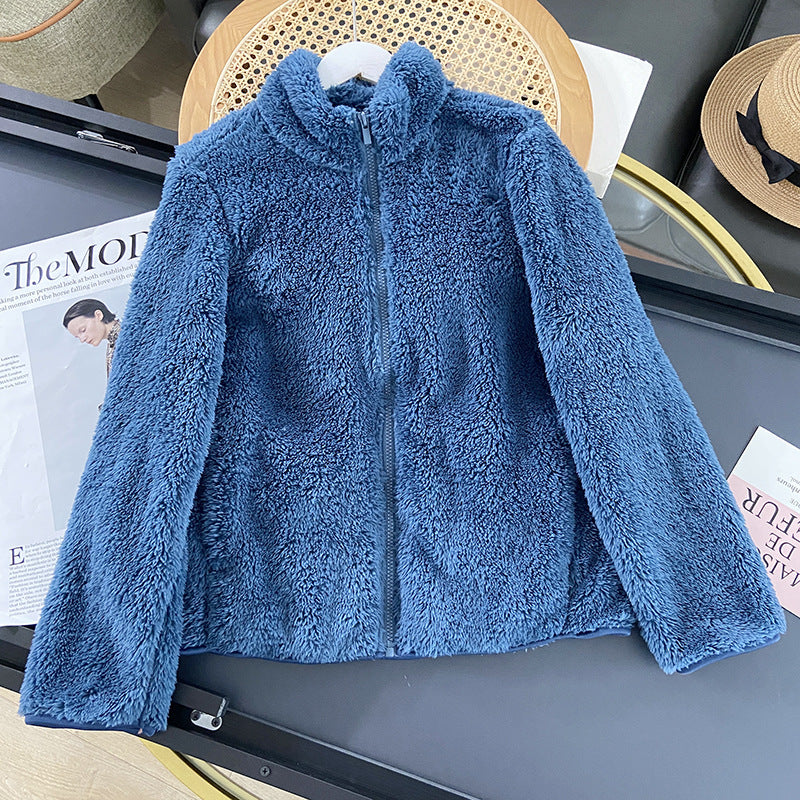 Giacca in pile blu su tavolo, chiusa con zip, stile casual. Perfetta per l'inverno, calda e morbida. Accessorio moda autunnale.