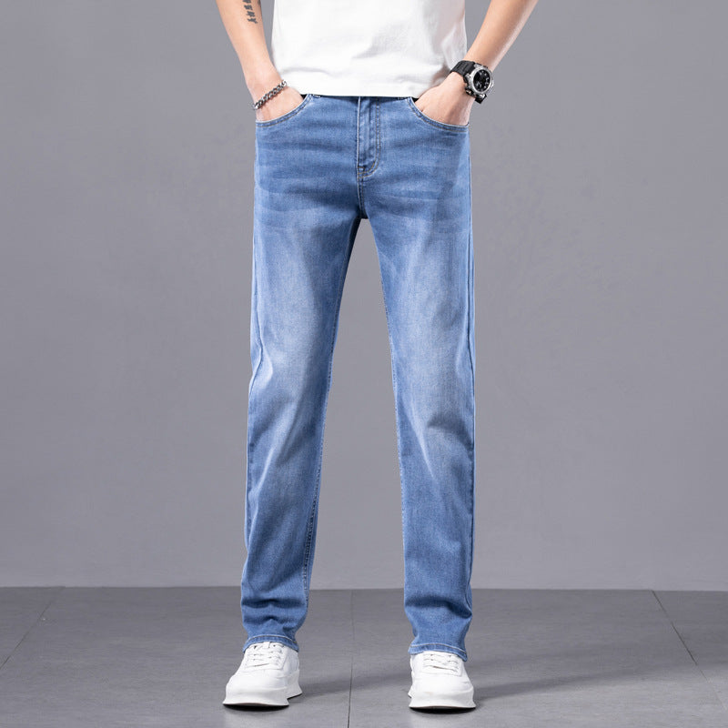 Jeans uomo blu chiaro, taglio dritto, indossati con t-shirt bianca e scarpe sportive bianche. Moda casual maschile, abbigliamento quotidiano.