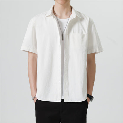 Camicia bianca uomo a maniche corte, stile casual, abbinata a t-shirt bianca e pantaloni neri. Look estivo elegante e moderno.