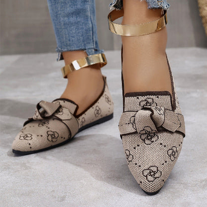 Scarpe da donna eleganti beige con fiocco e motivo floreale, cinturino dorato alla caviglia, abbinate a jeans. Scarpe moda casual chic.