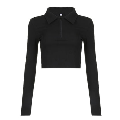 Maglia nera a maniche lunghe con zip frontale e colletto, design moderno e aderente, ideale per moda autunnale e look casual chic.
