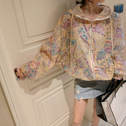 Giacca trasparente ricamata con motivi colorati, indossata da una donna con minigonna di jeans. Moda femminile, abbigliamento trendy, stile casual.