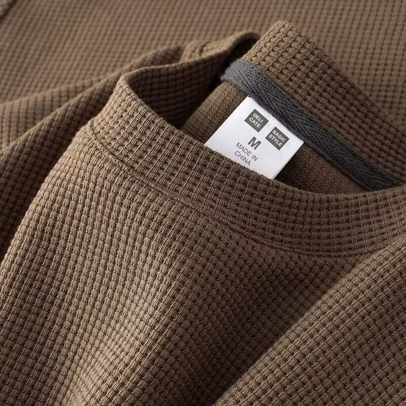 Maglia termica marrone a trama waffle, taglia M, etichetta "Made in China". Tessuto caldo e confortevole, ideale per l'inverno.