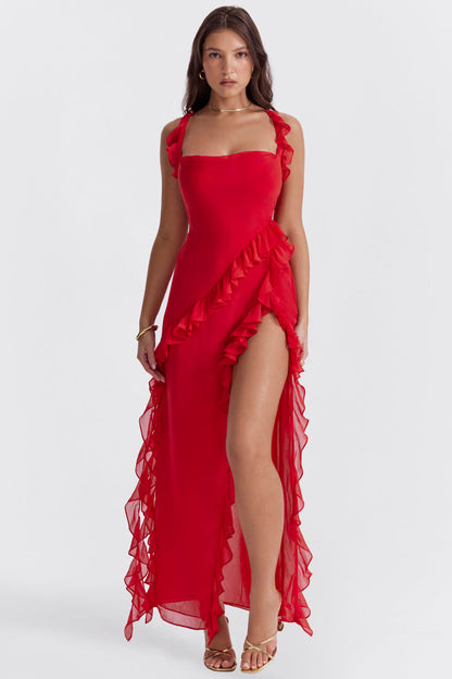 Donna in abito rosso elegante con volant, spacco alto e sandali dorati. Moda femminile, abbigliamento da sera, stile sofisticato.
