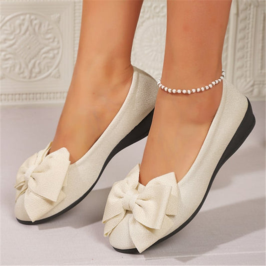 Scarpe ballerine bianche eleganti con fiocco, suola nera, indossate con cavigliera di perle. Design raffinato per look femminile e chic.