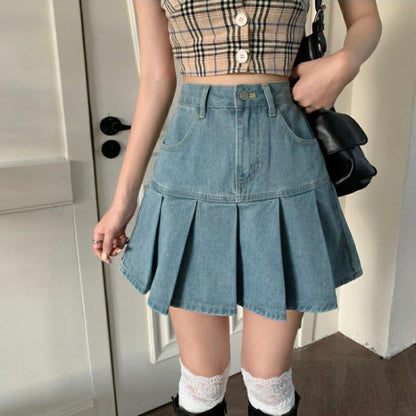 Donna con top a quadri e gonna di jeans a pieghe, borsa nera, calze bianche e stivali. Moda casual femminile, outfit estivo trendy.