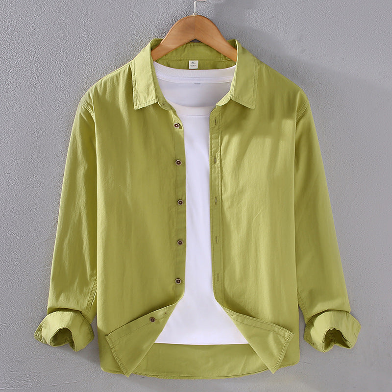 Camicia verde chiaro da uomo su gruccia, con colletto classico e maniche lunghe, abbinata a t-shirt bianca. Moda casual, abbigliamento maschile.