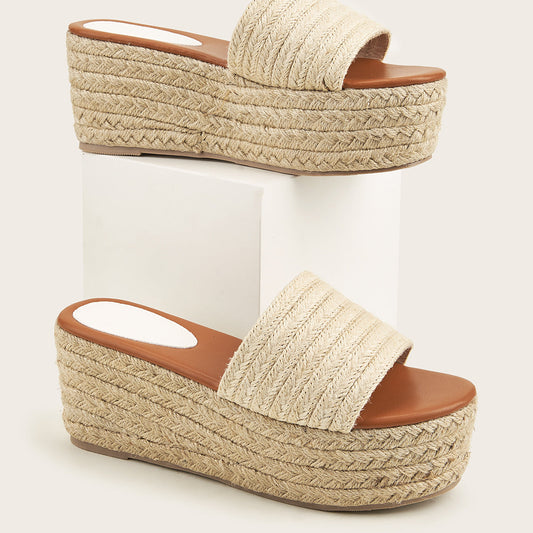 Sandali platform in rafia intrecciata beige su sfondo neutro. Scarpe estive con zeppa alta, design casual ed elegante. Moda donna, calzature trendy.