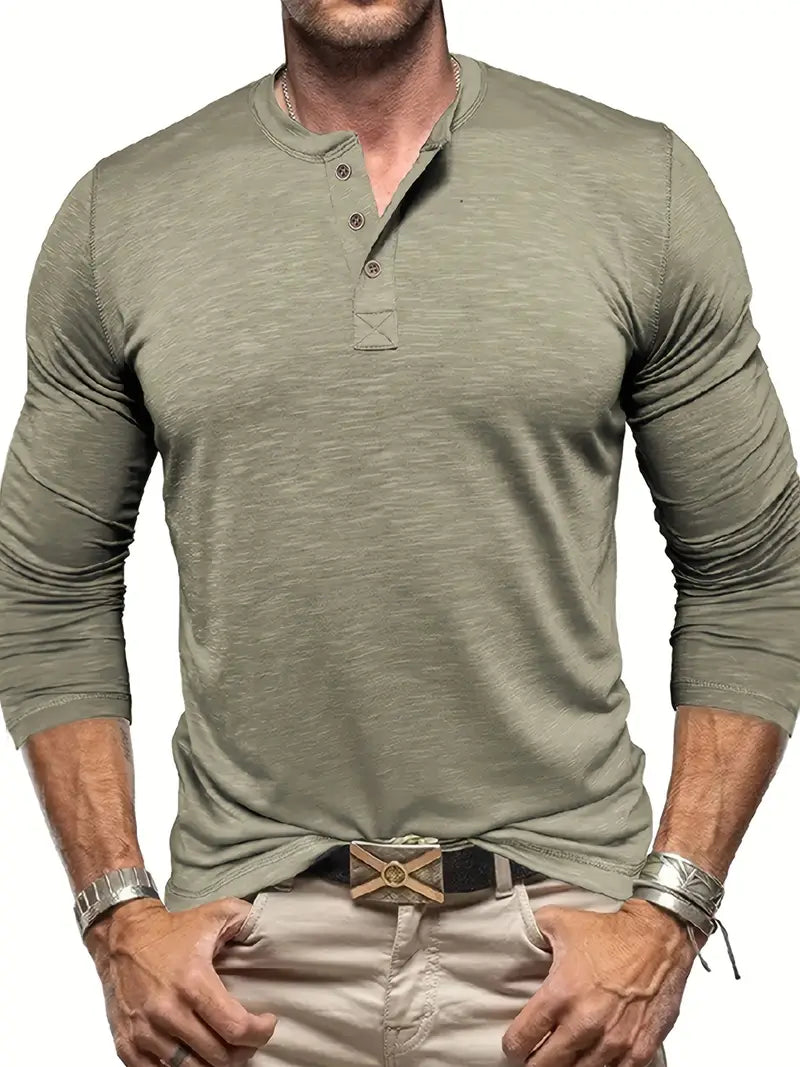 Uomo con maglia verde oliva a maniche lunghe e bottoni, pantaloni beige, cintura con fibbia decorativa, bracciali in metallo. Moda casual maschile.