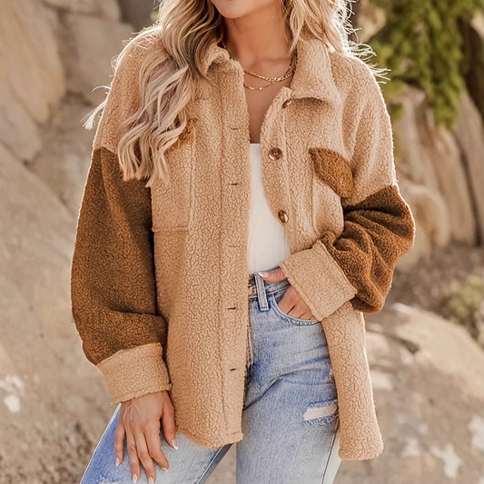 Donna con giacca teddy bicolore beige e marrone, jeans chiari, sfondo naturale. Moda autunnale, abbigliamento casual, stile trendy.