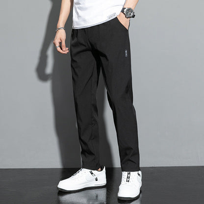 Pantaloni neri eleganti da uomo, abbinati a scarpe da ginnastica bianche e maglietta bianca, moda casual moderna.