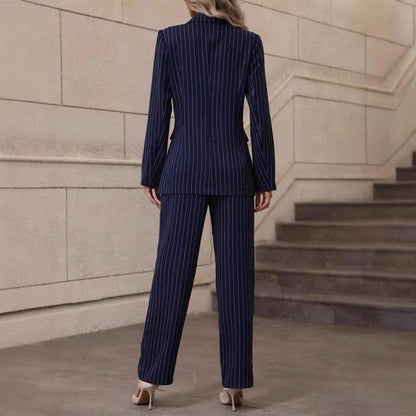 Donna in tailleur pantalone gessato blu scuro, vista posteriore, su sfondo di scale interne. Eleganza, moda femminile, abbigliamento formale.
