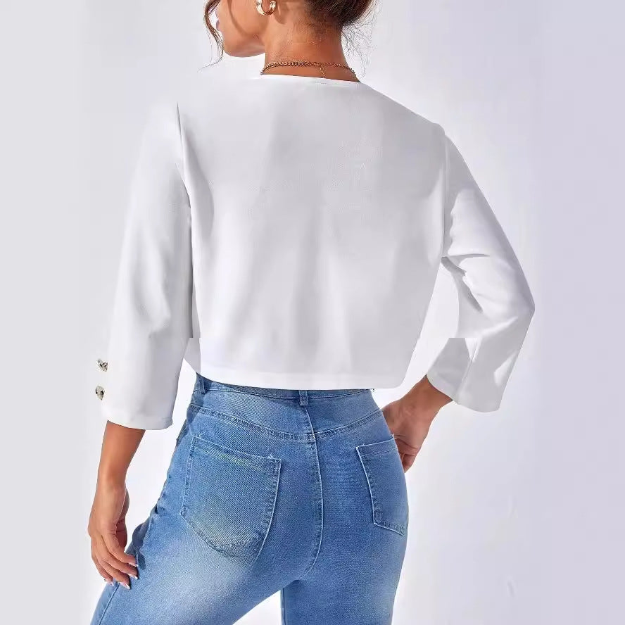 Donna di spalle indossa giacca bianca a maniche lunghe e jeans aderenti blu. Moda casual femminile, abbigliamento trendy, stile moderno.