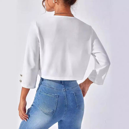 Donna di spalle indossa giacca bianca a maniche lunghe e jeans aderenti blu. Moda casual femminile, abbigliamento trendy, stile moderno.