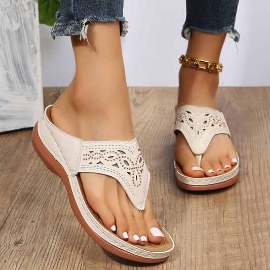 Sandali estivi donna in pelle traforata beige, suola comoda, indossati con jeans strappati e cavigliera dorata. Moda calzature casual eleganti.