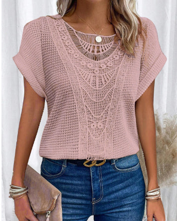 Donna con maglia rosa lavorata a maglia, dettagli traforati, indossa jeans blu e accessori argento. Stile casual chic, moda estiva femminile.