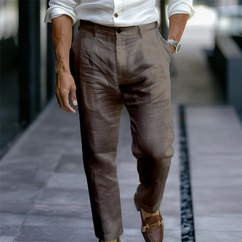 Uomo elegante in camicia bianca e pantaloni marroni, cammina su marciapiede. Indossa mocassini marroni e orologio. Moda maschile urbana.