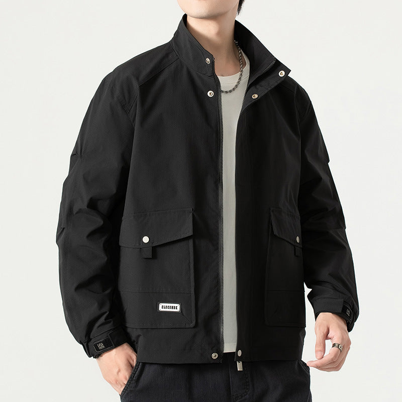 Giacca nera da uomo con tasche frontali e zip, indossata su maglietta bianca. Stile casual, ideale per moda autunnale e invernale.