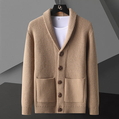 Cardigan beige in maglia a coste con bottoni in legno, tasche frontali e colletto a scialle, appeso su gruccia nera. Moda uomo autunno inverno.