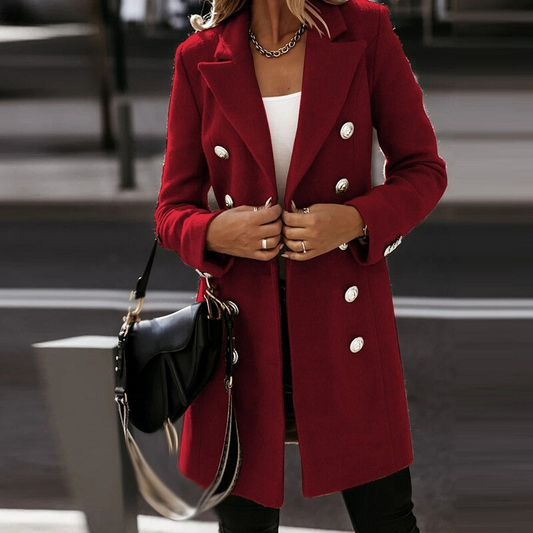 Donna con cappotto rosso elegante, bottoni dorati, borsa nera a tracolla. Moda autunnale, stile urbano chic. Abbigliamento femminile di tendenza.
