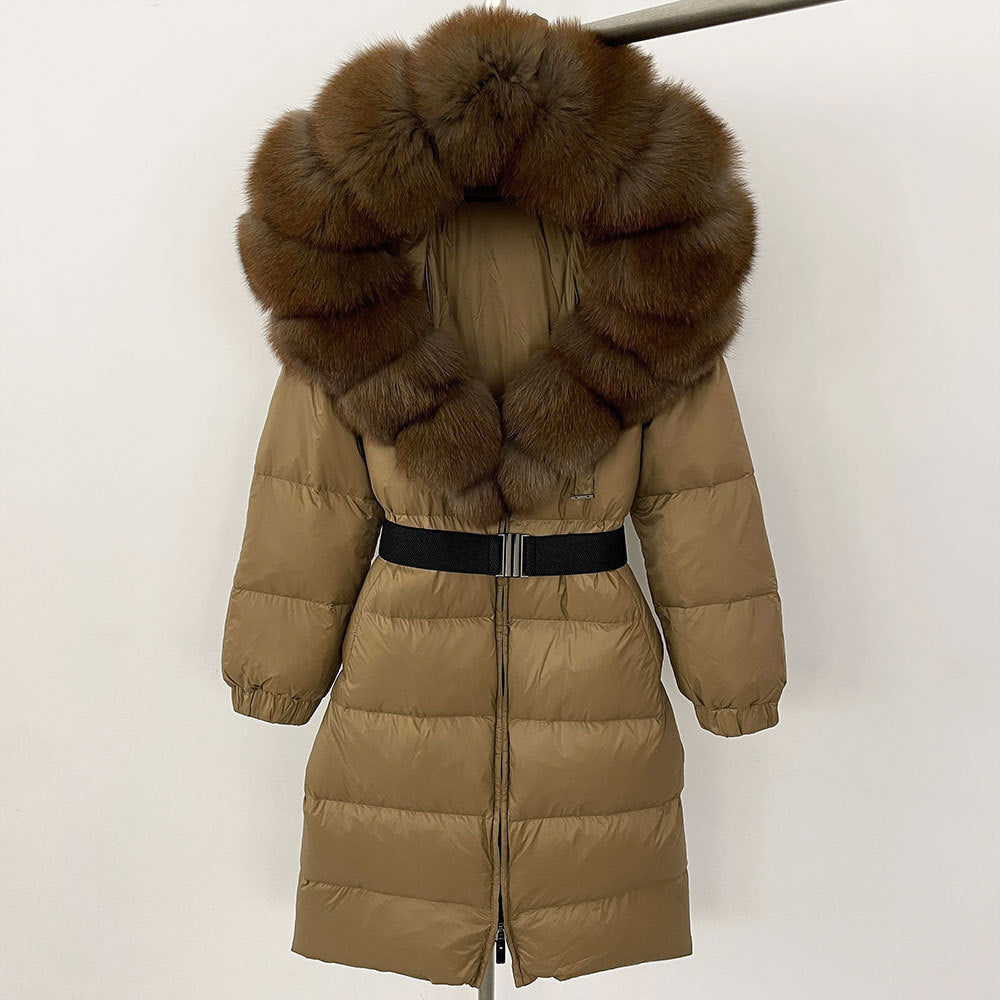 Piumino lungo marrone con cappuccio in pelliccia sintetica, cintura nera, design trapuntato, moda invernale donna, elegante e caldo.