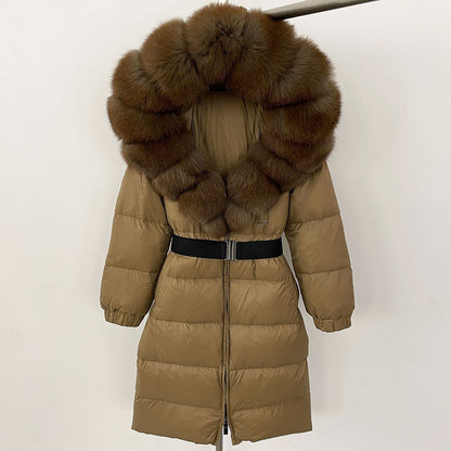Piumino lungo marrone con cappuccio in pelliccia sintetica, cintura nera, design trapuntato, moda invernale donna, elegante e caldo.