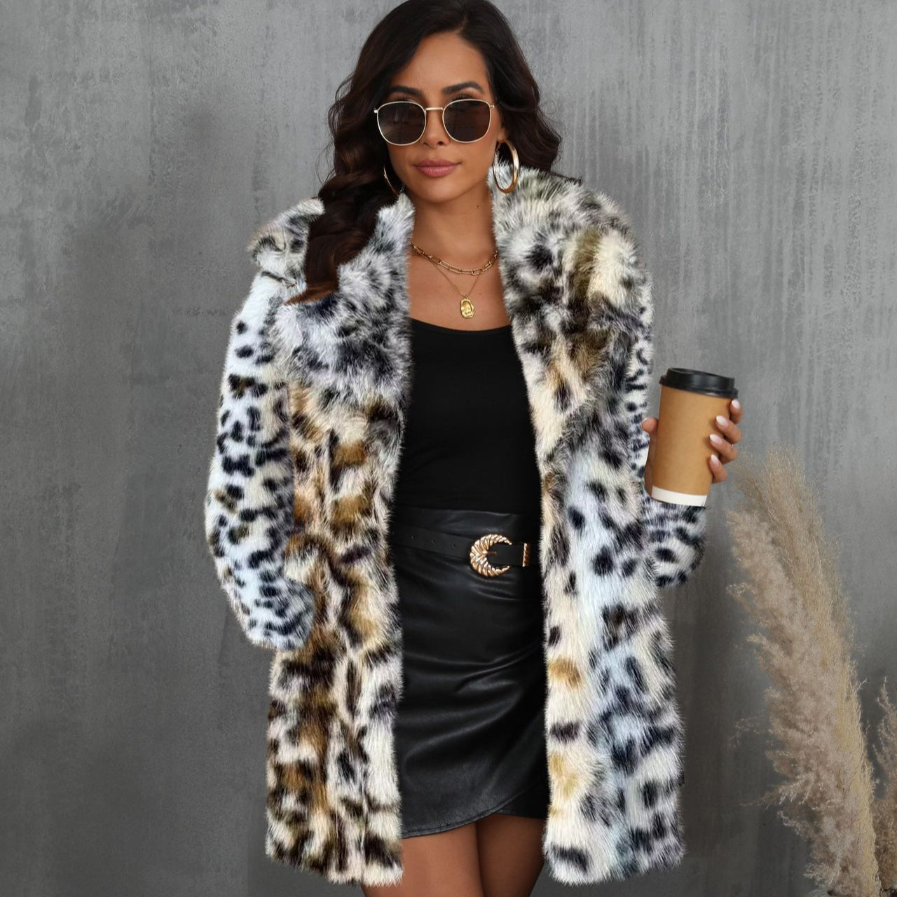 Donna con cappotto in pelliccia leopardata, occhiali da sole, abito nero e caffè in mano. Moda autunnale, stile elegante, tendenze 2023.