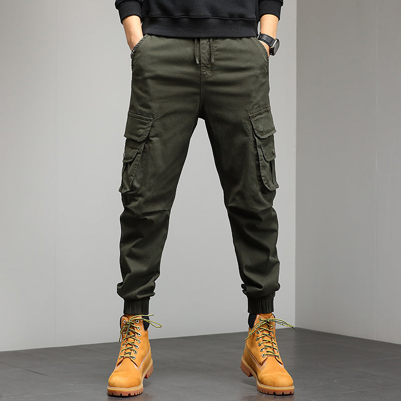 Pantaloni cargo verde militare da uomo con tasche multiple, abbinati a stivali gialli in pelle. Stile casual e funzionale per moda urbana.