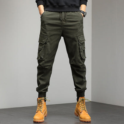 Pantaloni cargo verde militare da uomo con tasche multiple, abbinati a stivali gialli in pelle. Stile casual e funzionale per moda urbana.