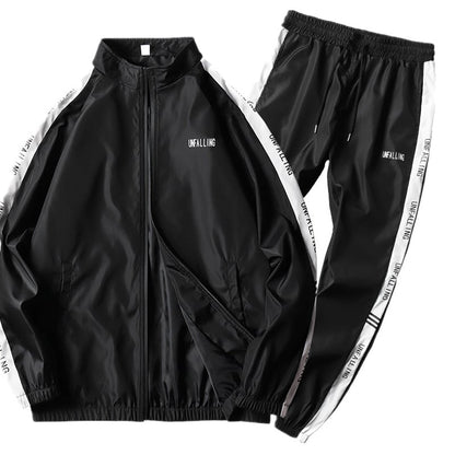 Tuta sportiva nera unisex, giacca e pantaloni con strisce bianche laterali, scritta "UNFALLING", abbigliamento casual e alla moda.