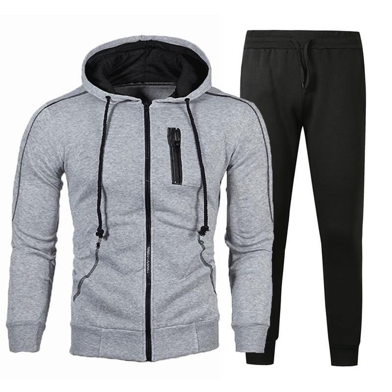 Tuta sportiva uomo, felpa grigia con cappuccio e zip, pantaloni neri. Abbigliamento casual, comodo per palestra e tempo libero.