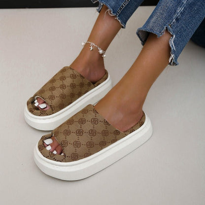 Sandali donna con zeppa alta, motivo monogramma marrone, jeans strappati, cavigliera argento. Scarpe estive moda, tendenze calzature 2023.