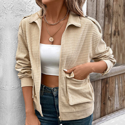 Donna con giacca beige a quadri, top bianco, collana dorata. Moda autunnale casual, stile urbano, abbigliamento femminile trendy.