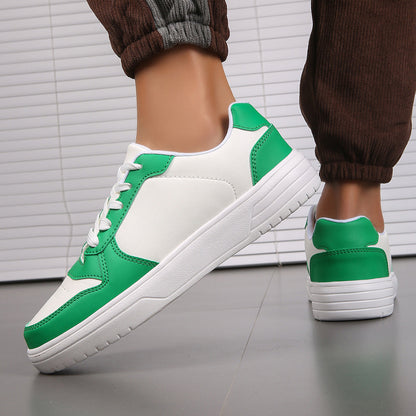Scarpe da ginnastica bianche e verdi su pavimento grigio, indossate da una persona con pantaloni marroni. Design moderno, moda casual.