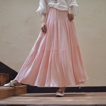 Gonna lunga rosa in tessuto leggero, indossata con camicia bianca e scarpe basse. Moda femminile elegante, abbigliamento estivo casual.