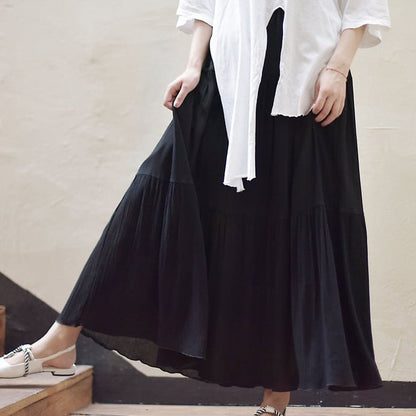 Donna con gonna lunga nera e camicia bianca, scarpe eleganti. Moda femminile, abbigliamento casual chic, stile minimalista.