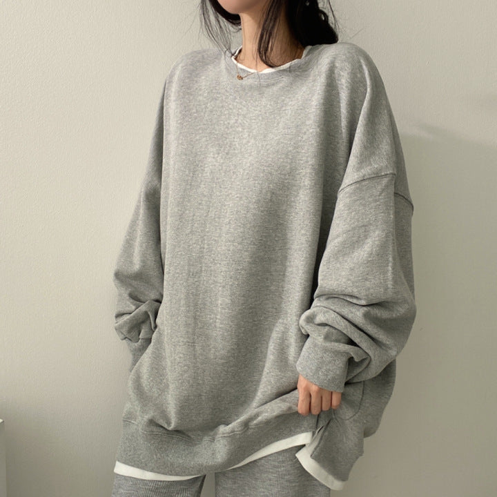 Donna con felpa oversize grigia, stile casual, moda autunnale. Abbigliamento comodo, tendenze streetwear, look minimalista, outfit quotidiano.