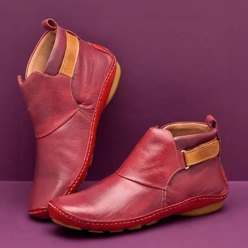 Scarpe in pelle rossa da donna su sfondo viola, design moderno con chiusura a strappo, suola in gomma antiscivolo. Calzature eleganti e comode.