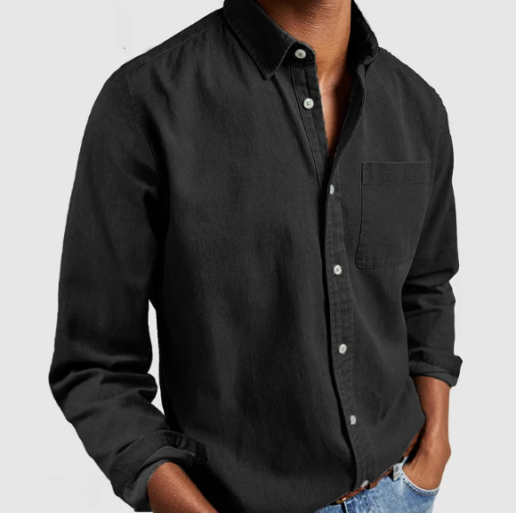 Camicia nera da uomo in cotone, maniche lunghe, colletto classico, abbinata a jeans chiari. Stile casual ed elegante per moda maschile.