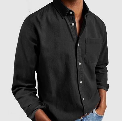 Camicia nera da uomo in cotone, maniche lunghe, colletto classico, abbinata a jeans chiari. Stile casual ed elegante per moda maschile.