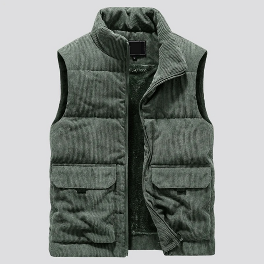 Gilet imbottito verde in velluto a coste, senza maniche, con tasche frontali e chiusura a zip. Elegante e caldo, ideale per l'inverno.