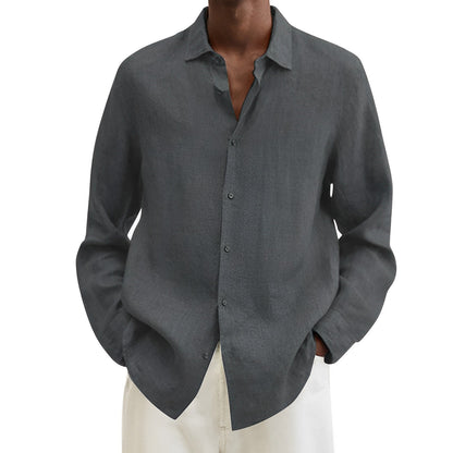 Camicia uomo grigia in lino, maniche lunghe, colletto classico, abbinata a pantaloni bianchi. Elegante e casual, ideale per moda estiva.