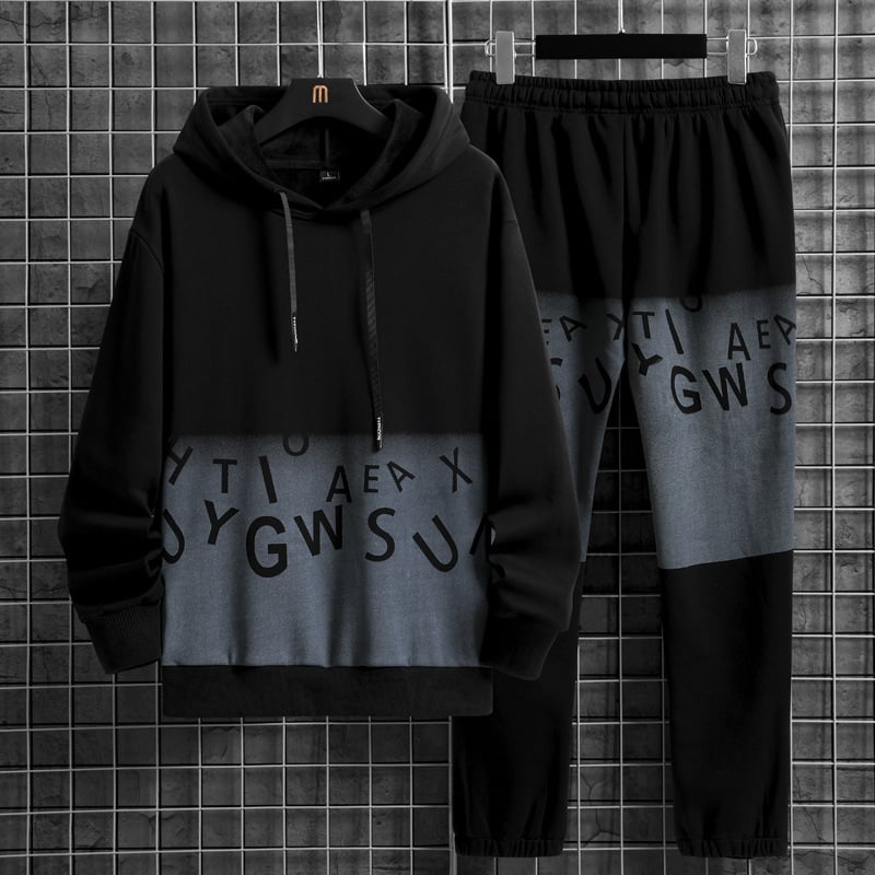 Set tuta uomo nero e grigio con cappuccio, lettere stampate, su sfondo griglia. Abbigliamento casual, moda streetwear, stile moderno.