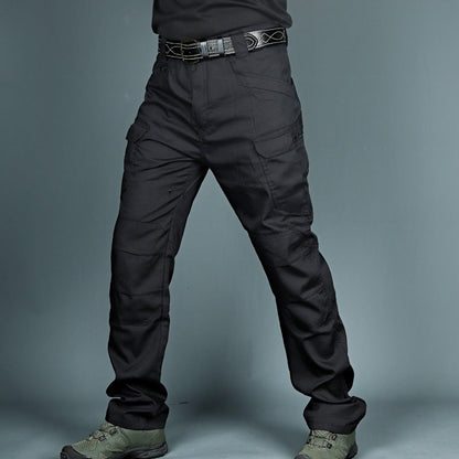 Pantaloni tattici neri da uomo, con tasche cargo e cintura, indossati con scarponi verdi. Abbigliamento militare resistente e funzionale.