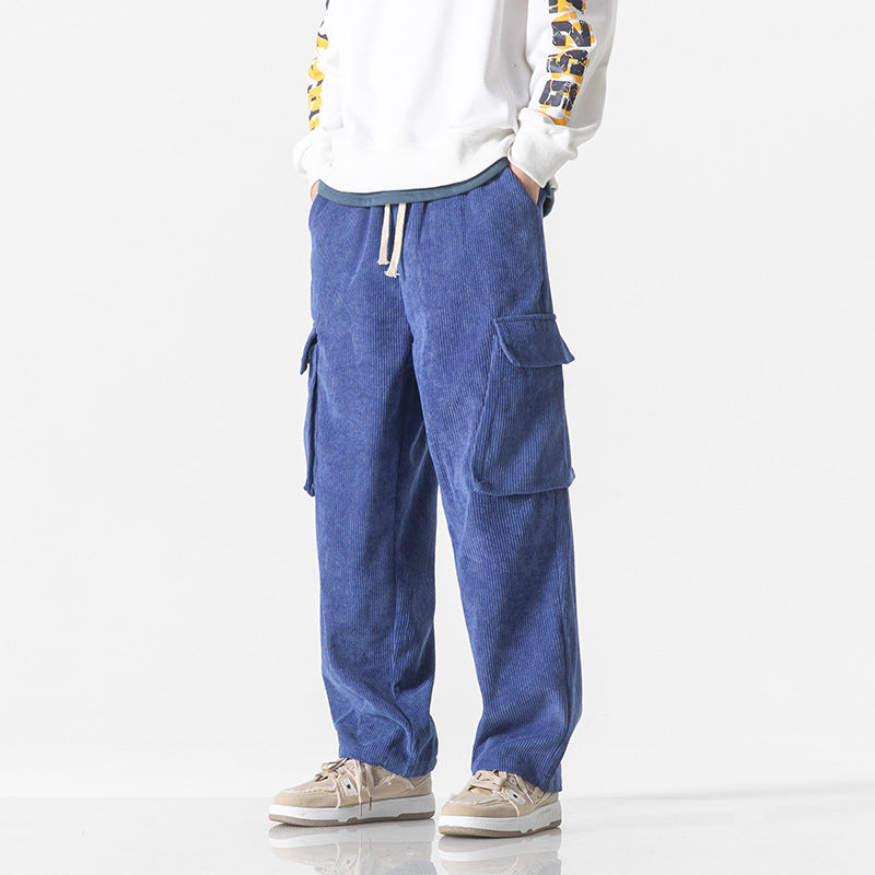 Pantaloni cargo blu da uomo, tasche laterali, stile casual, abbinati a felpa bianca e sneakers beige. Moda streetwear, abbigliamento comodo.