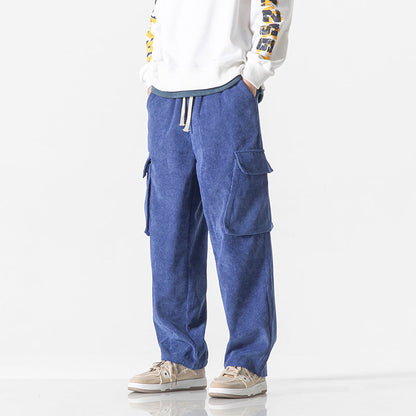Pantaloni cargo blu da uomo, tasche laterali, stile casual, abbinati a felpa bianca e sneakers beige. Moda streetwear, abbigliamento comodo.