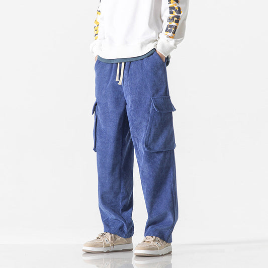 Pantaloni cargo blu da uomo, tasche laterali, stile casual, abbinati a felpa bianca e sneakers beige. Moda streetwear, abbigliamento comodo.