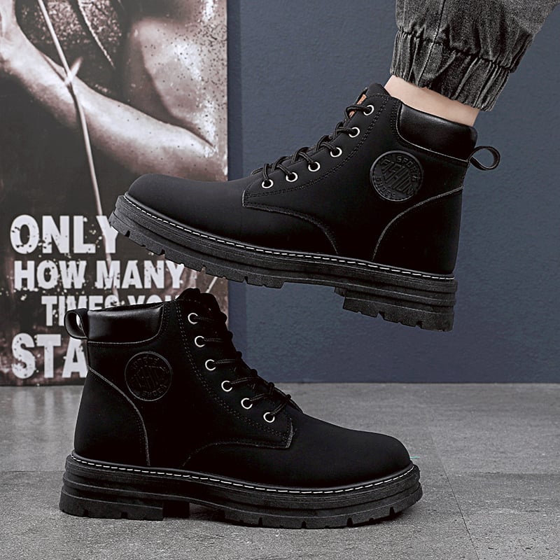 Stivali neri da uomo in pelle, suola robusta, lacci, logo laterale, indossati con jeans. Scarpe moda autunno inverno, stile casual urbano.